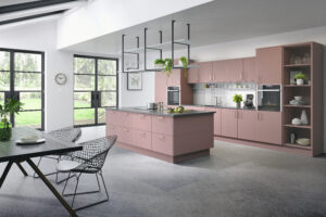 Modern kitchen with Cutler Superior Matt doors in Antique Rose (pink), featuring an island and dining area