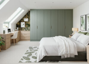 Large wardrobe with vertical groove Arko doors, in Reed Green and Light Casella Oak, with brass handles in a modern bedroom.