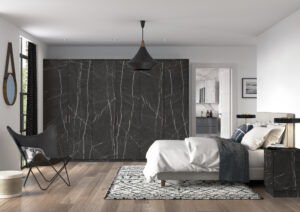 Modern bedroom with dark marble-finish wardrobe with Edged Soho doors, black butterfly chair, and open view into matching marble bathroom