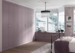 French lavender (light purple) built-in wardrobe with Painted Balair doors, in a cozy bedroom with bay window seating