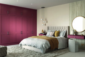 Large Superior Matt Tuscan Red wardrobe with Allerford doors,with vertical handles in a modern bedroom
