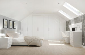 Bright attic bedroom with white Glacier high gloss built-in wardrobes, slanted ceiling with skylights, geometric wallpaper, and white desk setup